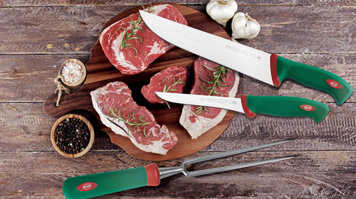 Sanelli couteaux sur une planche à découper avec de la viande de steak